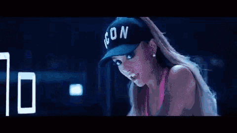 a group of women are riding exercise bikes in a dark room .