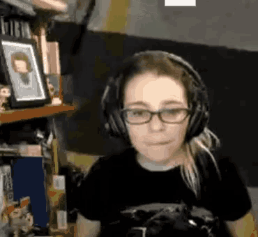a woman wearing glasses and headphones is sitting in front of a computer .