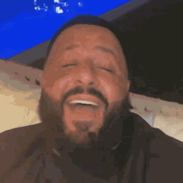 a man with a beard is making a funny face with his tongue out .