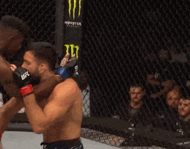 a man in a boxing ring with a monster energy sign in the background