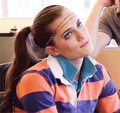 a woman wearing a headband and a striped shirt looks up at something