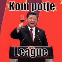 a man in a suit and tie is holding a glass of wine in front of a podium with kom potje league written on it