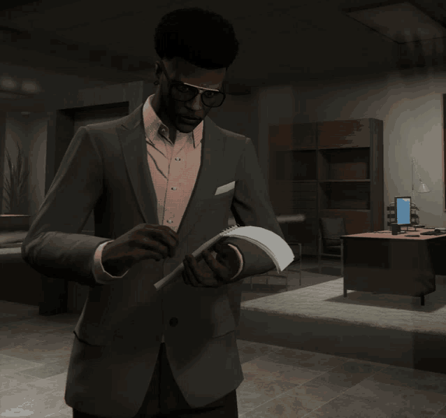 a man in a suit and glasses is reading a book in an office
