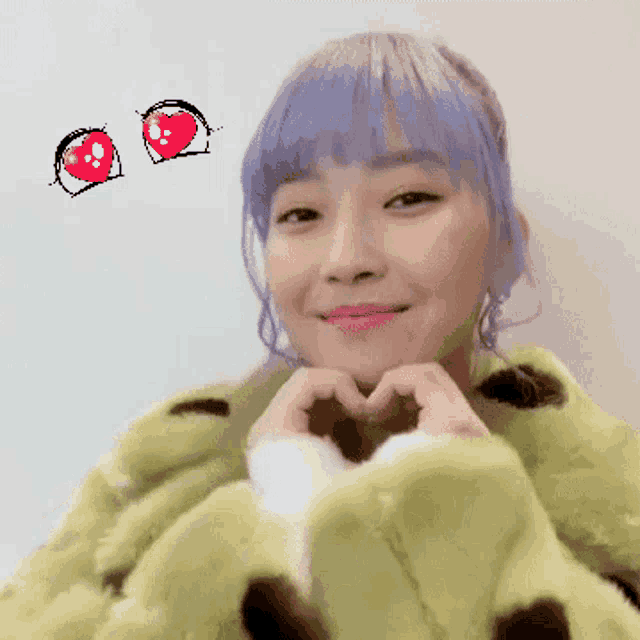 a woman with purple hair is making a heart with her hands