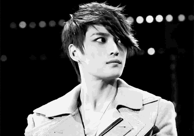 a black and white photo of a young man with a very long haircut