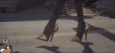 a woman is walking down the street wearing high heels and a cowboy hat .