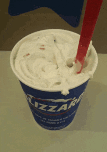 a cup of dairy queen ice cream has a red spoon in it