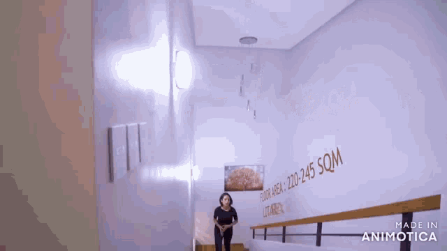 a woman is walking down a set of stairs with a sign on the wall that says floor index