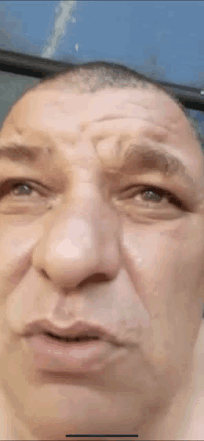 a man with a shaved head is making a funny face