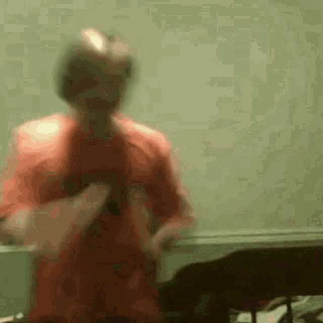 a man in a red shirt is dancing in a room .
