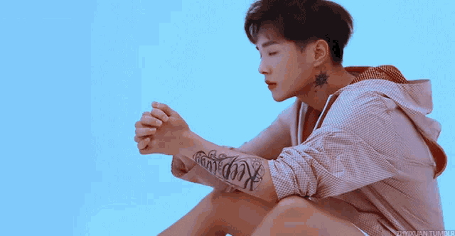 a young man with a tattoo on his arm that says king on it