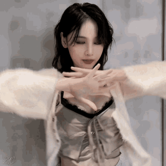 a woman with her eyes closed is wearing a white cardigan and a black bra