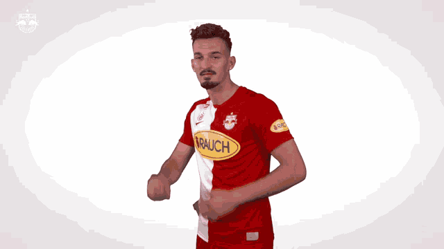 a man in a red and white jersey with a yellow rauch logo on his chest