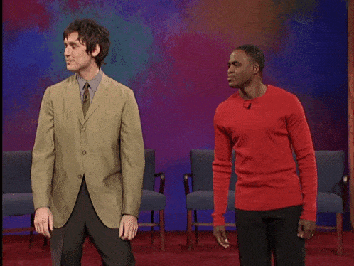 a man in a red sweater stands next to another man
