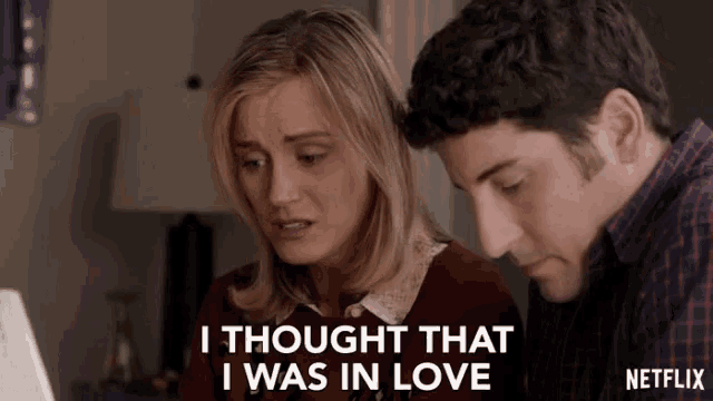 a man and a woman are looking at a laptop and the woman is saying " i thought that i was in love "