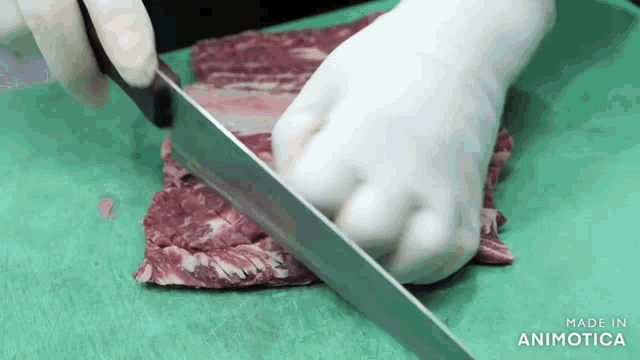 a person is cutting a piece of meat on a cutting board