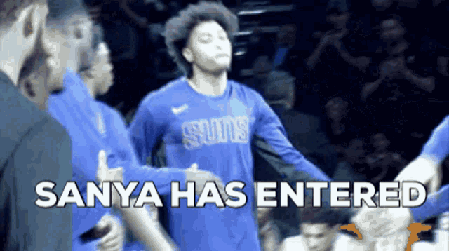 a basketball player wearing a blue shirt that says suns