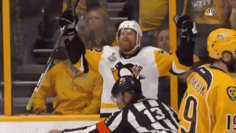 a hockey player with the number 13 on his jersey stands in front of a referee