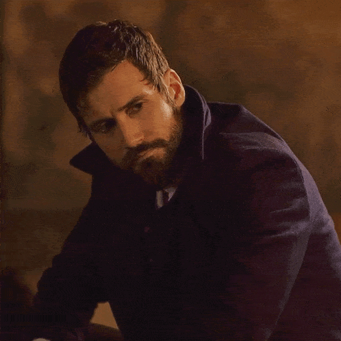 a man with a beard is wearing a purple jacket