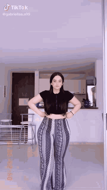 a woman is standing in a room with her hands on her hips and a tiktok watermark on the bottom