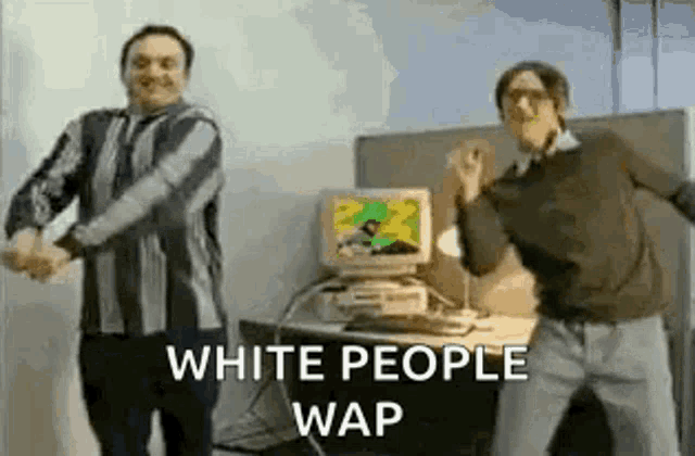 two men are dancing in front of a computer in a room .