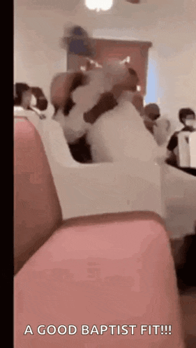a group of people are sitting in a church with the words `` a good baptist fit '' written on the screen .