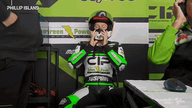 a motorcycle racer wearing a green and white outfit with the letters cip on the front