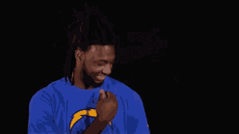 a man in a blue shirt is clapping his hands .