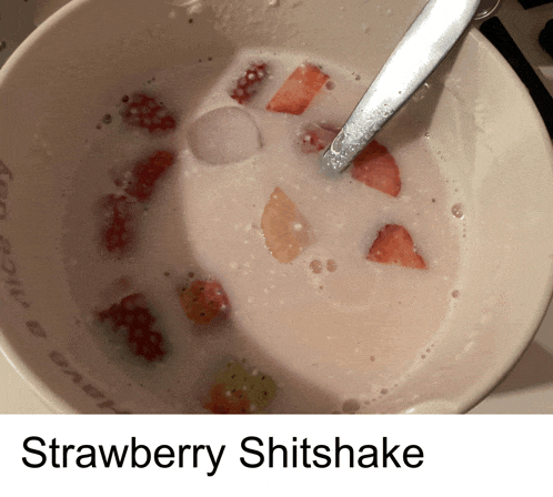 a bowl of strawberry shitshake with a spoon