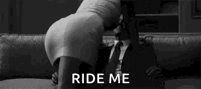 a woman is kneeling on a man 's lap on a couch and asking him to ride her .