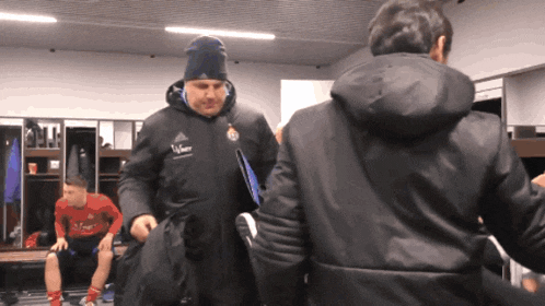 a man wearing a black jacket with the word adidas on the front