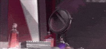 a woman is sitting in front of a mirror in a room with perfume bottles and a mirror .