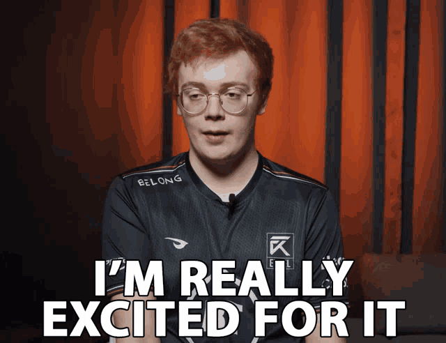 a man wearing glasses and a belong shirt says " i 'm really excited for it "