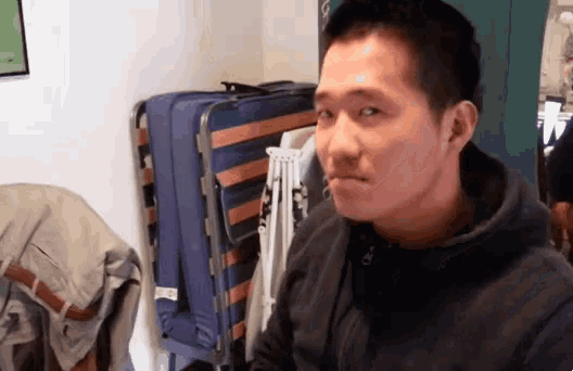 a man wearing a black hoodie looks at the camera