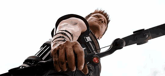 a close up of a person holding a bow and arrow in their hand .