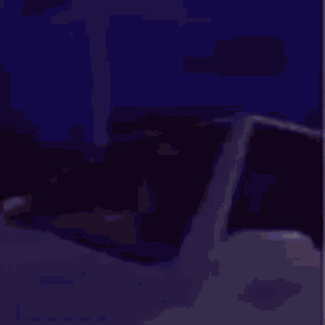 a white car is driving down a road at night with a purple background .
