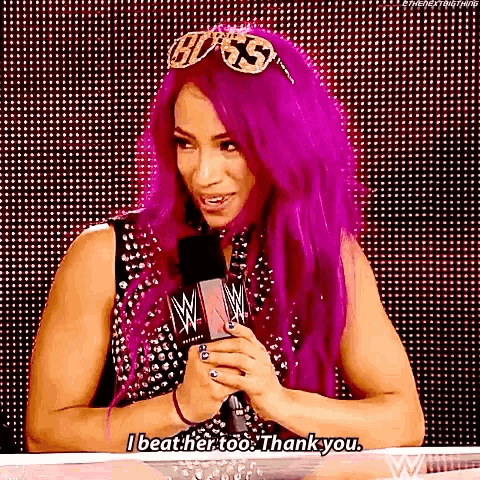 a woman with purple hair is talking into a microphone and saying `` i beat her too , thank you . ''