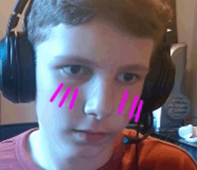 a young boy wearing headphones and a microphone has pink lines on his face