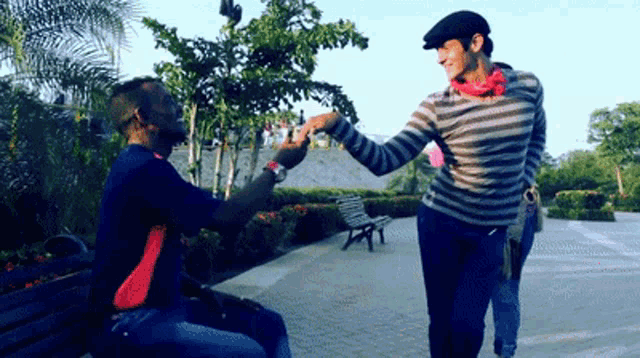 a man in a striped sweater holds the hand of another man