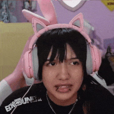 a girl wearing pink headphones and a shirt that says ecko unltd