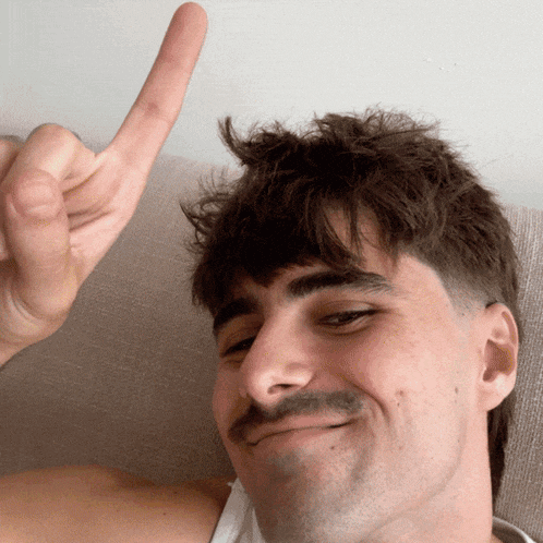 a man with a mustache is making a funny face and giving the middle finger