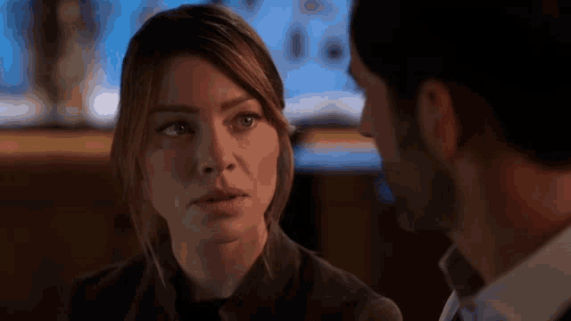 a man and a woman are looking at each other in a bar .