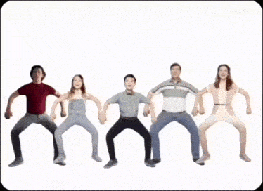 a group of people are standing in a row with their hands up .