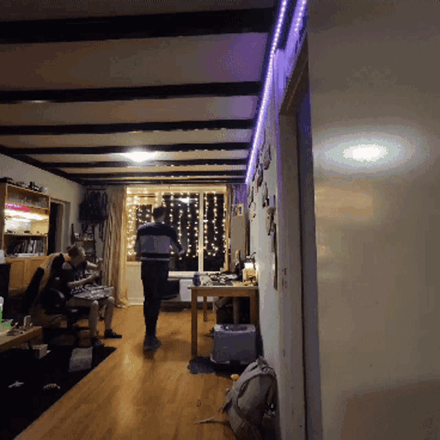 a man in a striped shirt stands in a living room
