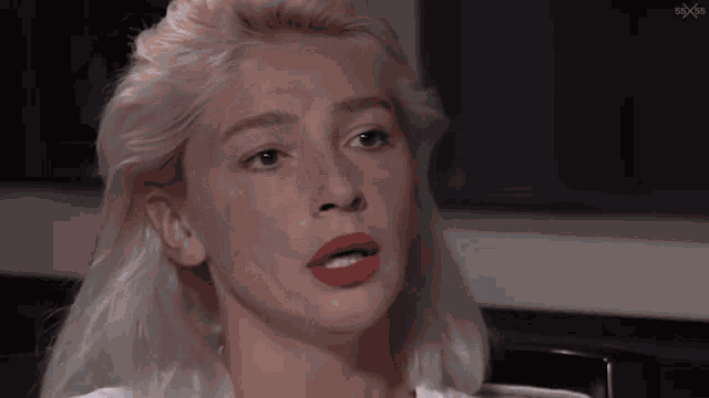 a close up of a woman 's face with red lipstick on her lips