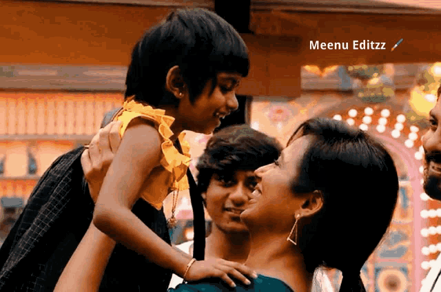 a woman is holding a little girl in her arms with meenu editzz written on the bottom right