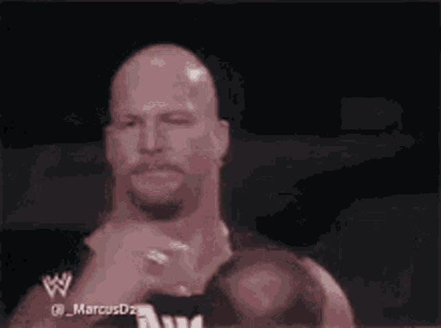 a bald man with a mustache and a ring on his finger is giving a thumbs up .