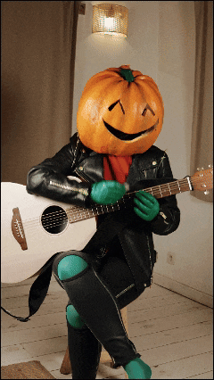 a person with a pumpkin on their head playing a guitar