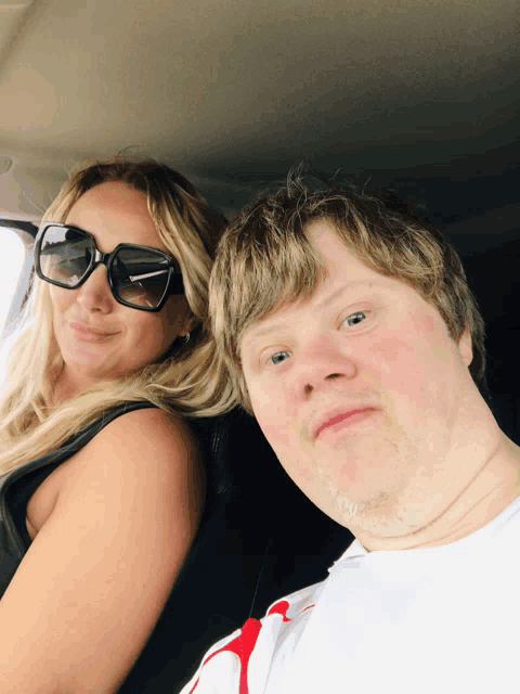 a woman wearing sunglasses sits next to a man