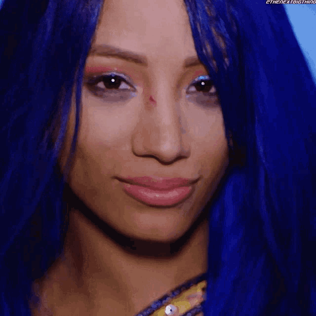 a close up of a woman with blue hair making a funny face